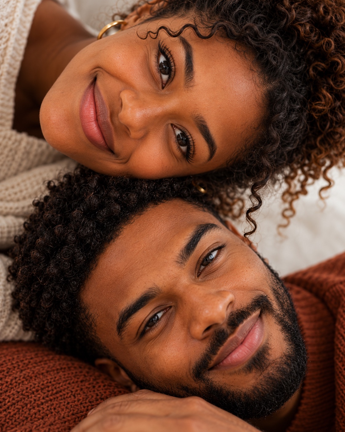 A couple relaxing together, smiling at the camera